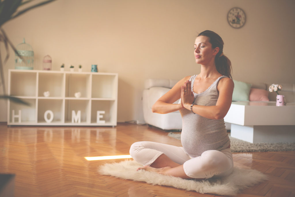 Pregnant woman practicing yoga breathing Healthy Mama Brand